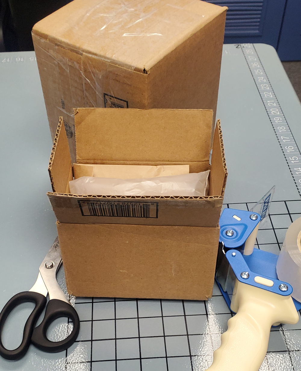 Open shipping box being professionally packed with cushioning and packing tools at Star MailHub and More in Roanoke, Virginia.