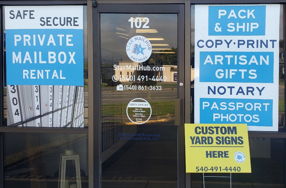 Storefront window signage with business services, branding, hours, and promotional graphics in Roanoke, Virginia