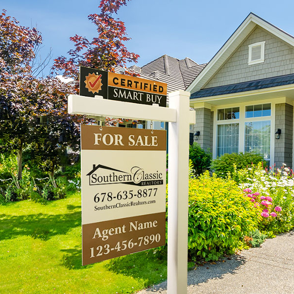 White residential real estate sign post installed in front of a home.
